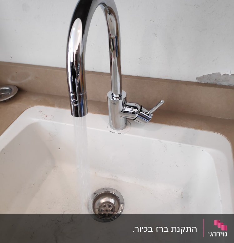 ברז מים זורמים בכיור לבן